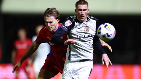 Mitch Pinnock of Bromley chased by Will Sutton of Oldham Athletic