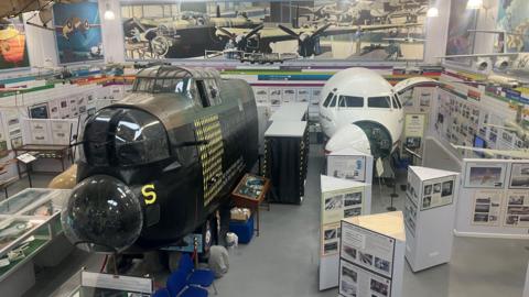 Photograph of the inside of the Avro Heritage Museum in Stockport. The image features the cockpit and fuselage of a Lancaster Bomber.