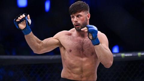 Karl Moore in action in blue mma gloves