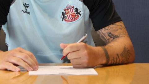 Close up of Sunderland player signing contract
