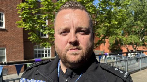 A policeman in uniform stood outside