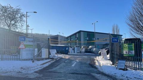 The entrance to Elland Household Waste Recycling Centre, with snow on the ground outside.