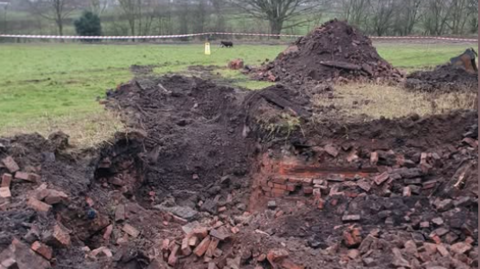 Exposed brickwork after an area of a field has been dug up 