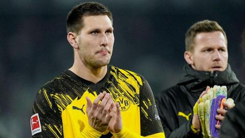 Niklas Sule applauds the Borussia Dortmund fans after their Bundesliga draw at Freiburg in December 2025
