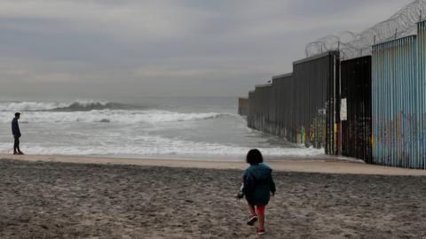 Jonathan Peralta, a migrant from Honduras, surveys the border wall