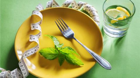 Leaf and measuring tape on a plate with lemon water