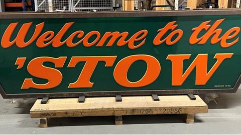 A big green sign that reads: Welcome to the 'Stow