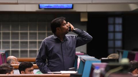 A Pakistani stockbroker watches share prices on monitor during a trading session at the Pakistan Stock Exchange (PSX) in Karachi