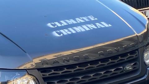 Car with 'climate criminal' written on the bonnet