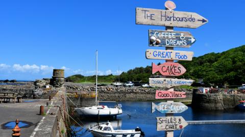 A harbour with small boats and sigs to local stores