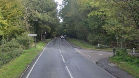 A road junction, with foliage either side, with a sign saying Coopersale, with an arrow to the right