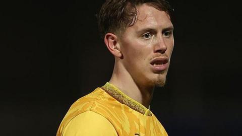 Hayden Muller in an amber Sutton United shirt