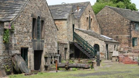 Stone industrial buildings with a staircase and grinding wheels