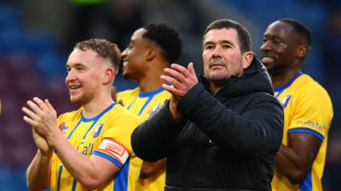Manager Nigel Clough stands with his players and claps his hand in appreciation after Mansfield beat Burnley in the FA Cup