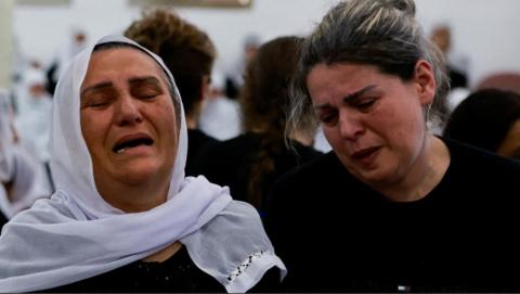 Two women mourn at funerals for children killed in a rocket attack at Majdal Shams on the Israeli occupied Golan Heights (28/07/24)