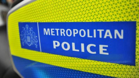 A yellow and blue sign containing the white words "METROPOLITAN POLICE"
