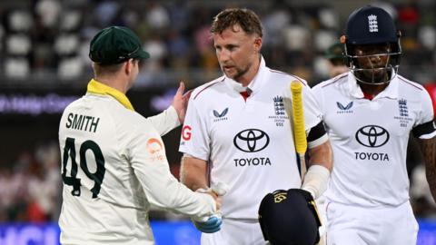 Joe Root shakes hands with Steve Smith after batting while Jofra Archer walks off behind him