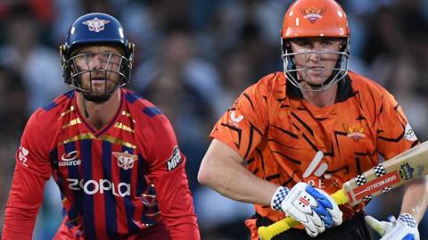 Manchester Super Giants wicketkeeper Jos Buttler (left) and Sunrisers Leeds batter Harry Brook (right) watch the ball after the latter hits a shot