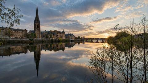 Perth, its old buildings reflected in the calm waters of the Tay.