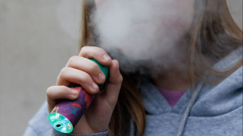 A teenage girl vaping 