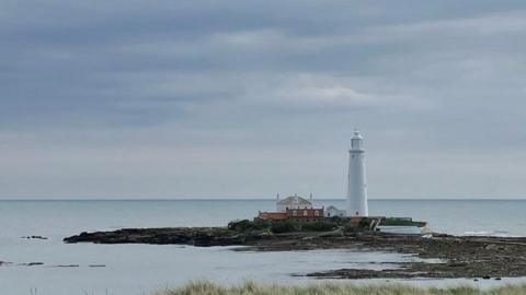 Grey clouds over a white lighthouse 