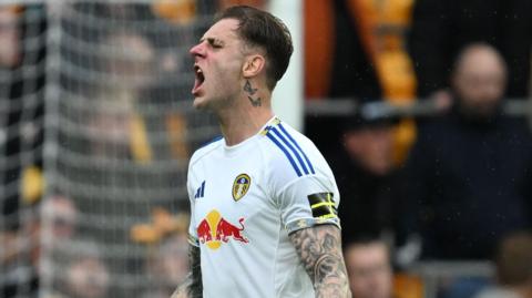 Wearing a white Leeds United shirt, Joe Rodon shouts