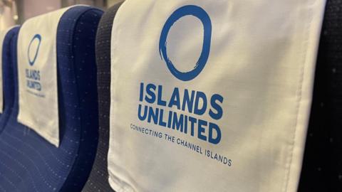 A close-up of the Islands Unlimited logo draped over a seat on the boat.