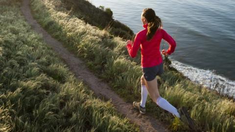 Woman running near cliff