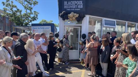 Crowds gather outside shop building where recovery hub is based in Blackpool