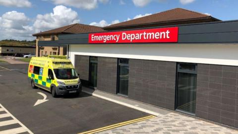 The front of Telford A&E, there is a large sign and an ambulance parked outside