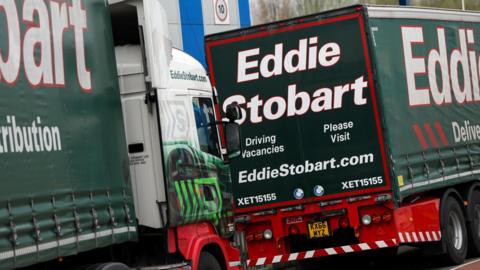 Two green lorries which has 'Eddie Stobart' written on the sides. 