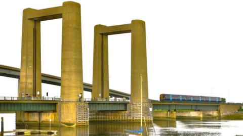 The Kingsferry Bridge, connecting mainland Kent with the Isle of Sheppey, with a Southeastern train crossing it.