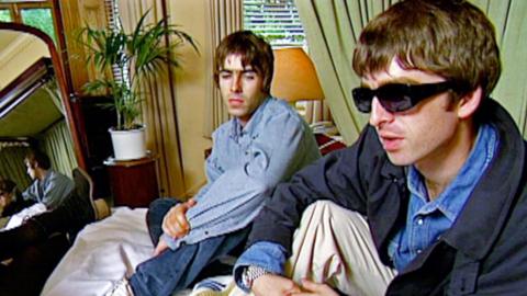 Liam and Noel Gallagher sitting in a hotel room, during an interview with Zoe Ball.