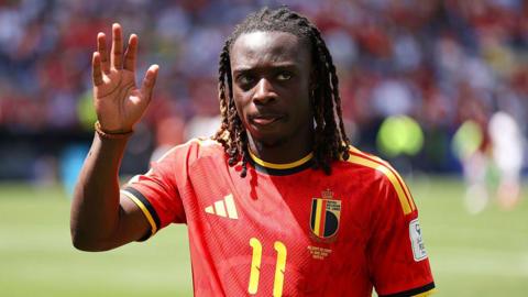 Jeremy Doku waves to the crowd while playing for Belgium