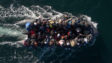 An inflatable dinghy carrying around 65 migrants crosses the English Channel.