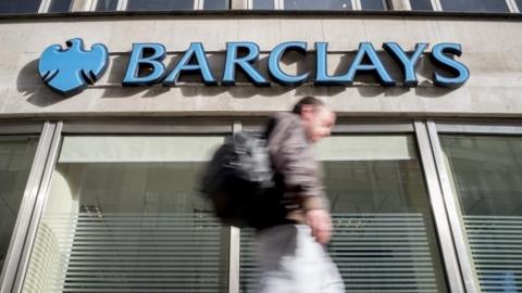 Man walking past Barclays branch
