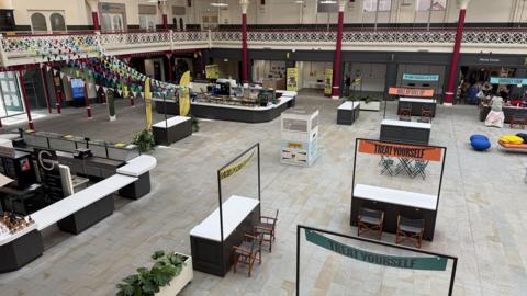 Above view of the new Market Hall in Derby, showing empty stalls, units and pop-up stalls and low footfall.