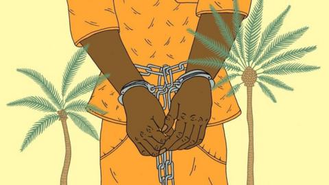 A man in chains next to some palm trees