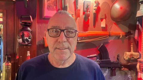 Ray Fricker in front of WW2 memorabilia