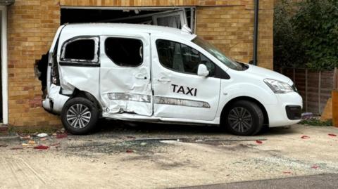 A picture of the white taxi with red plastic littered around it.