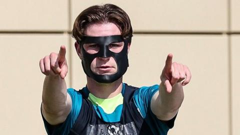 Alex Scott wearing his mask