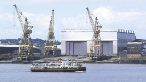 Mersey Ferry in River Mersey in front of shipping yard cranes