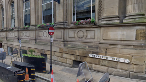 A grand brick building with a sign on the bottom corner saying Bennetts Hill