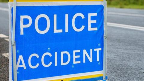 Police accident sign, white bold letters on blue background, on a road.