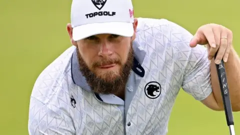 Tyrrell Hatton lining up a putt