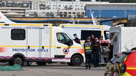 Firefighters provide assistance to an injured migrant after a vessel carrying dozens trying to cross the Channel to England sank off the northern French coast in Boulogne-sur-Mer, northern France on September 3, 2024