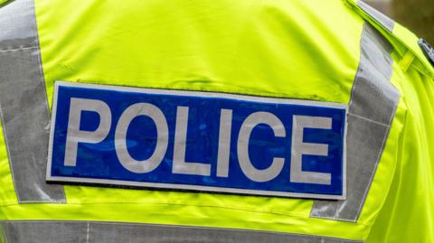 The logo on the back of a reflective jacket worn by UK police.