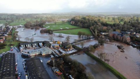 A drone shot of the River Otter flowing onto neighbouring fields