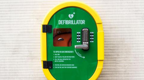 Emergency defibrillator mounted on an outside wall - stock photo