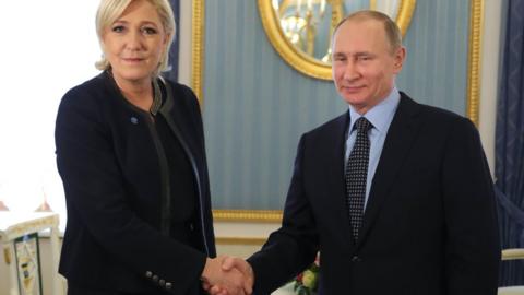 Marine Le Pen (L) shakes hands with Russian President Vladimir Putin (R) 24 March